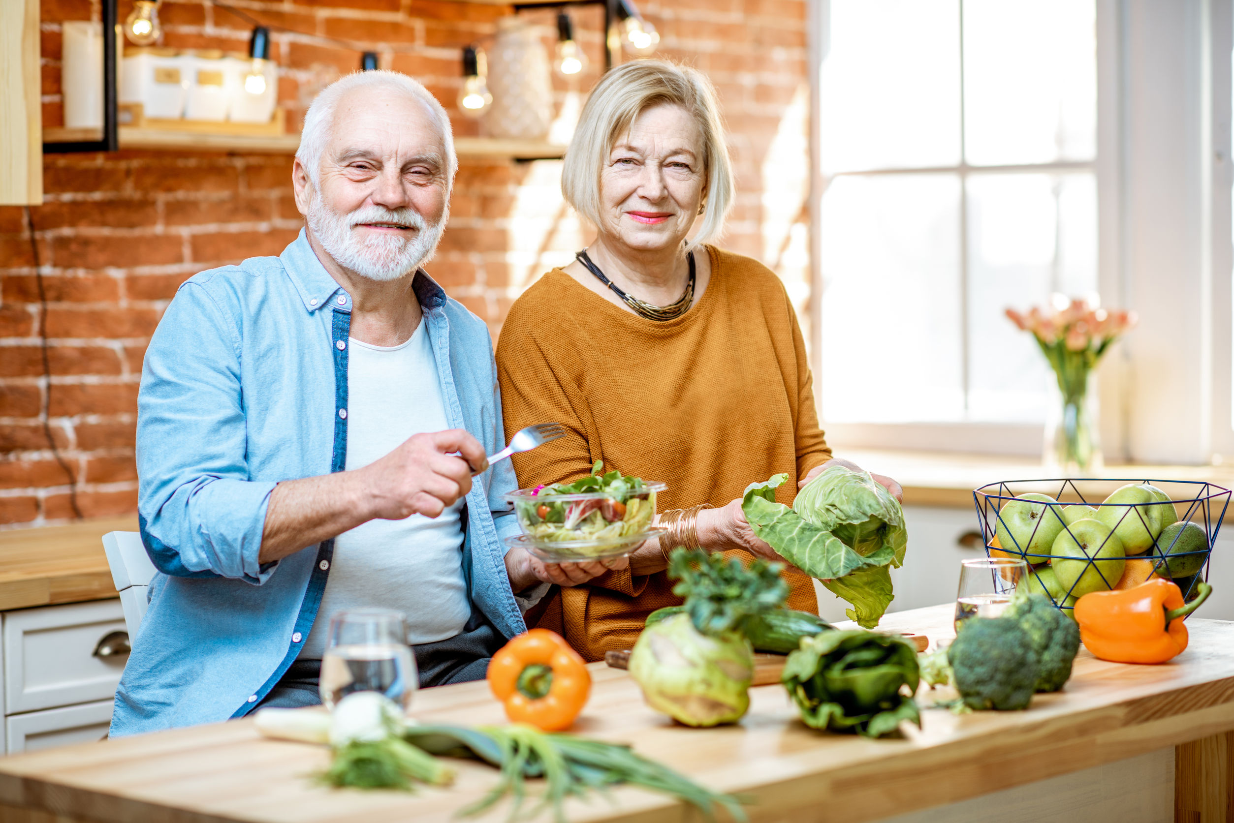 senior couple in kitchen with healthy food